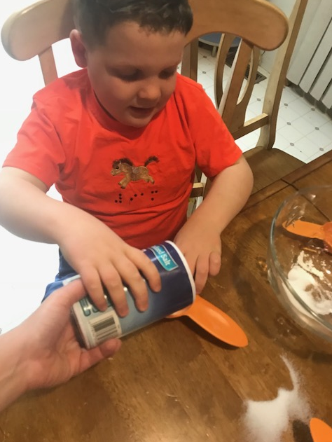 Liam pouring salt into the measuring cup