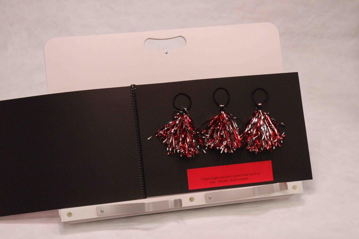 This Pom Pom book is an example of a book made for a child who visually functions in Phase II. The Red Pom Pom book is an example of book for children in Phase II.