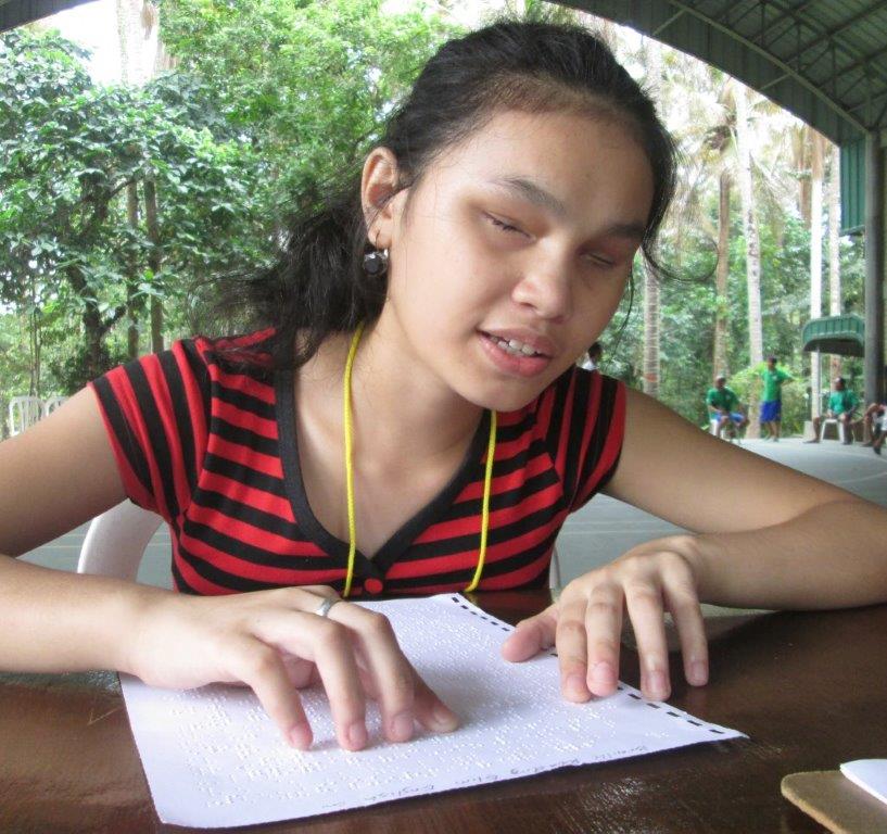 A girl reads a page of braille.
