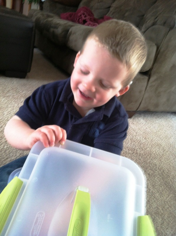 A young boy reaches inside a story box