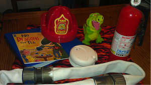 Kit includes a fireman's hat, fire extinguisher, a dragon doll, and a fire hose