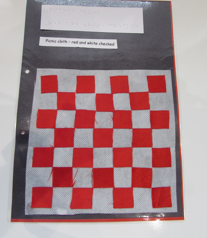 tactile picnic cloth with red and white checkers on black paper