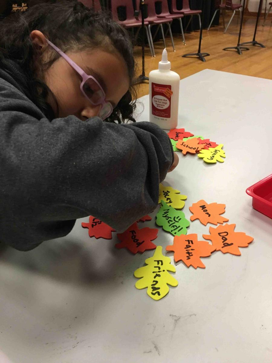 A girl arranges her leaves of thanks.