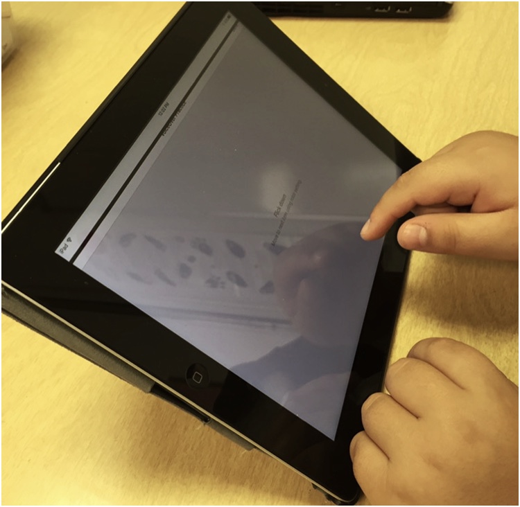 student finger above iPad VoiceOver practice screen