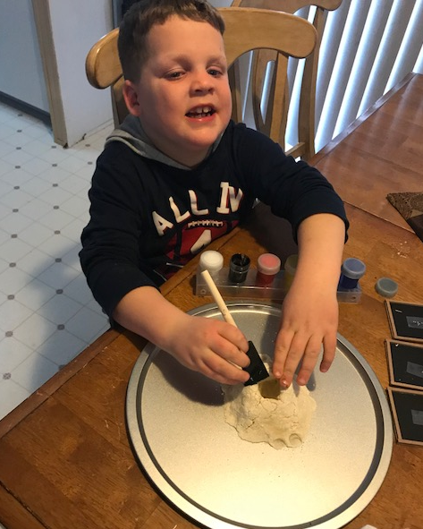 Liam painting the volcano with a sponge brush