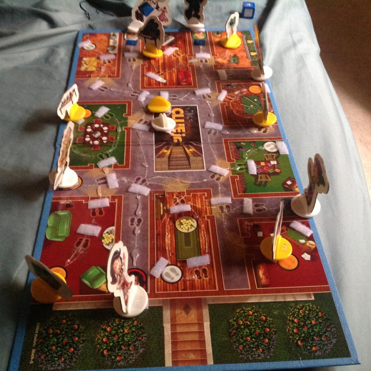 Clue Jr: case of the missing cake. The image is the game set up with the character and furniture pieces on the board. 