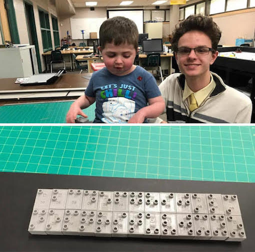 A young boy with a high school student who printed the 3D braille blocks