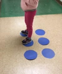 Student standing on dots 1 and 2 to make braille letter 