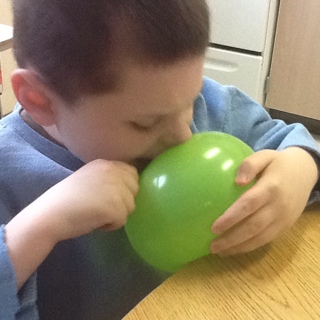 A boy explores a water balloon.