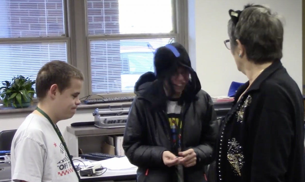 Two teenage boys and a woman wearing cat ears