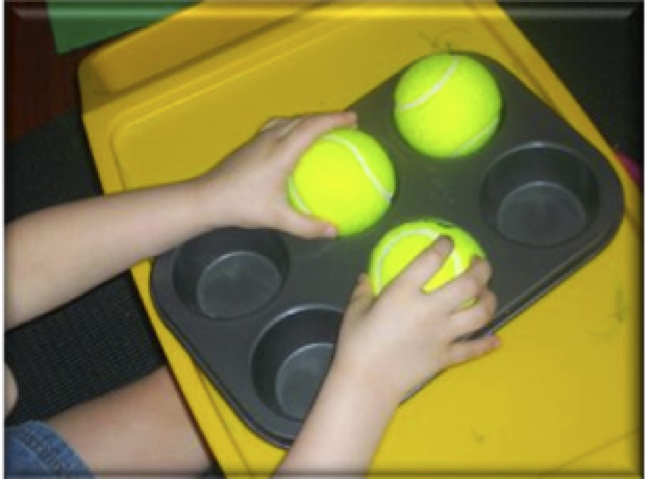 muffin tin with tennis balls in the cups