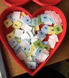 heart shaped box filled with tiles with braille and print letters on them