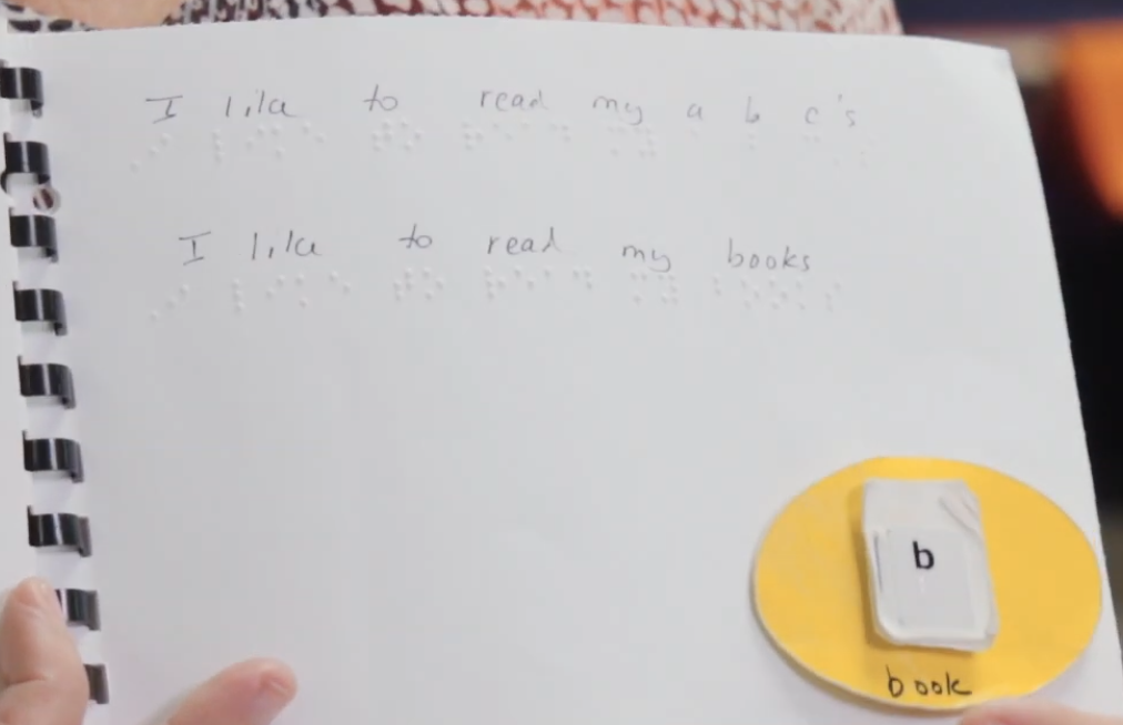 Braille book with tactile symbol for book