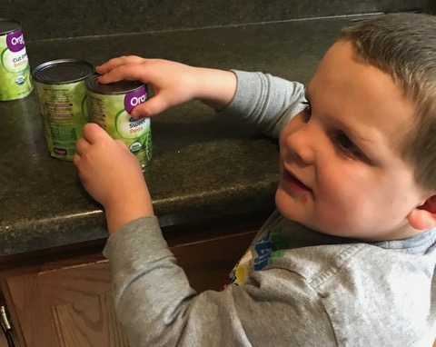 A boy reads braille on the can labels