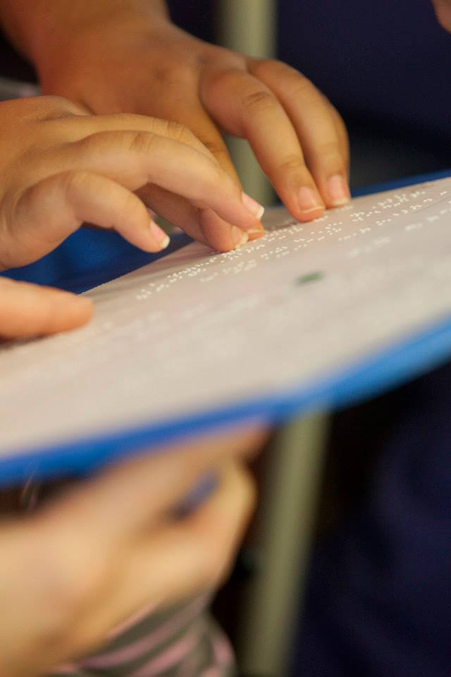 A child's hands reading braille