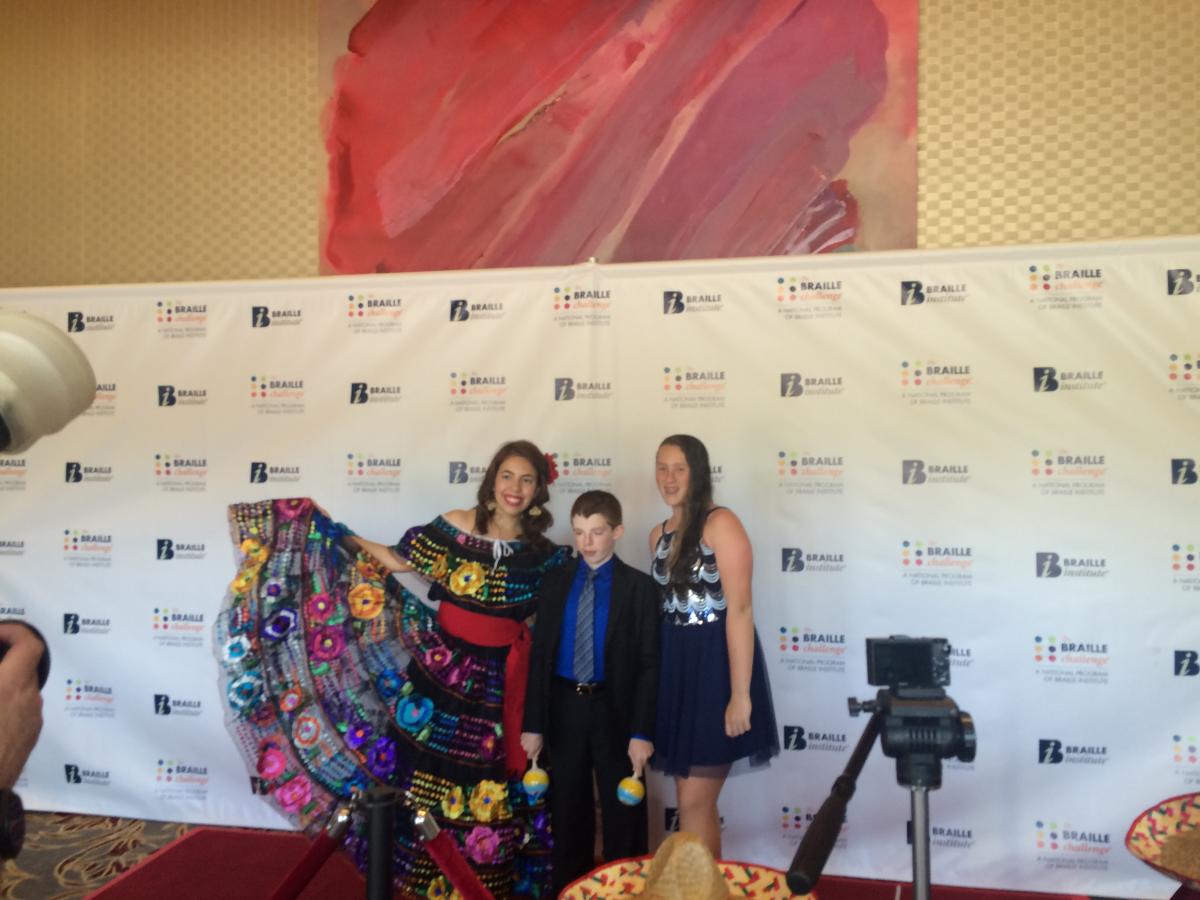 two women and a boy on the red carpet at the Braille Challenge Gala