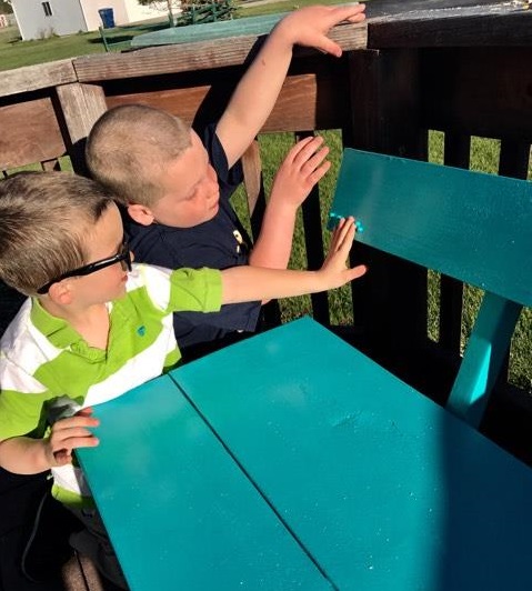 Liam and Finn feeling the braille on the bench