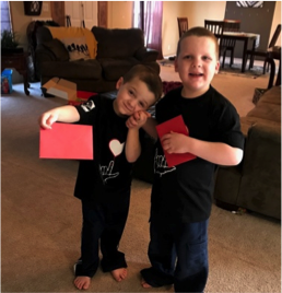 Two brothers holding holiday cards.