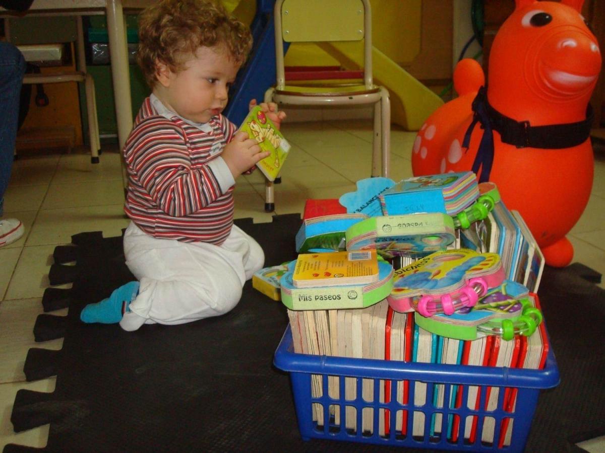 A young child explores tactile books.