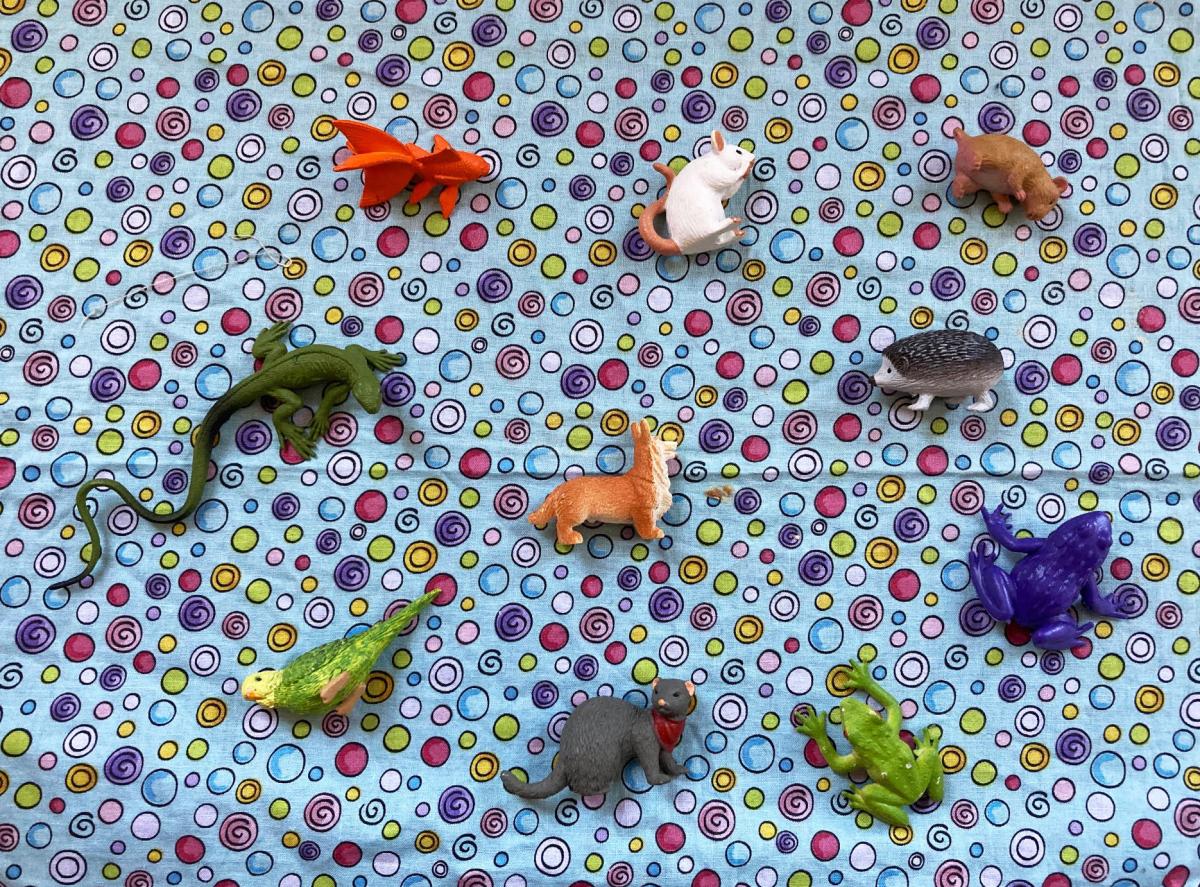 Multiple small plastic animals on blue patterned background