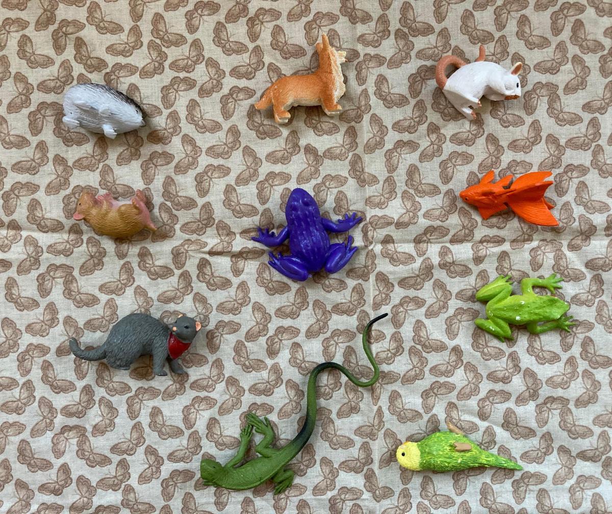 Multiple small plastic animals on brown patterned background