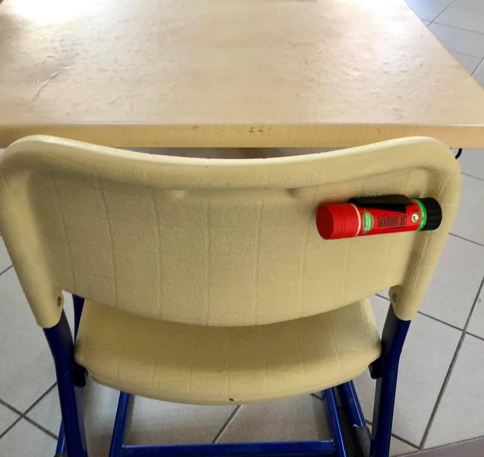 A glue stick on the back of the chair tells students where to sit for art projects.