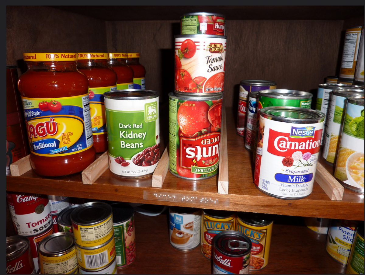 Canned goods are separated into categories and a braille label appears next to diced tomatoes.