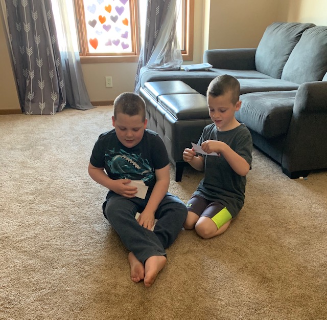 Two boys reading exercise cards in print and braille