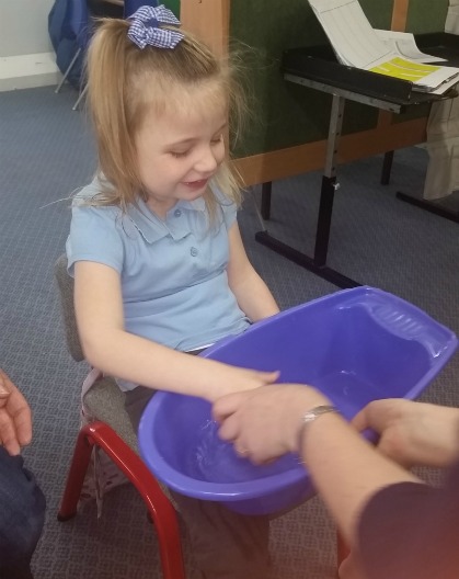 A young girl explores a tub of water