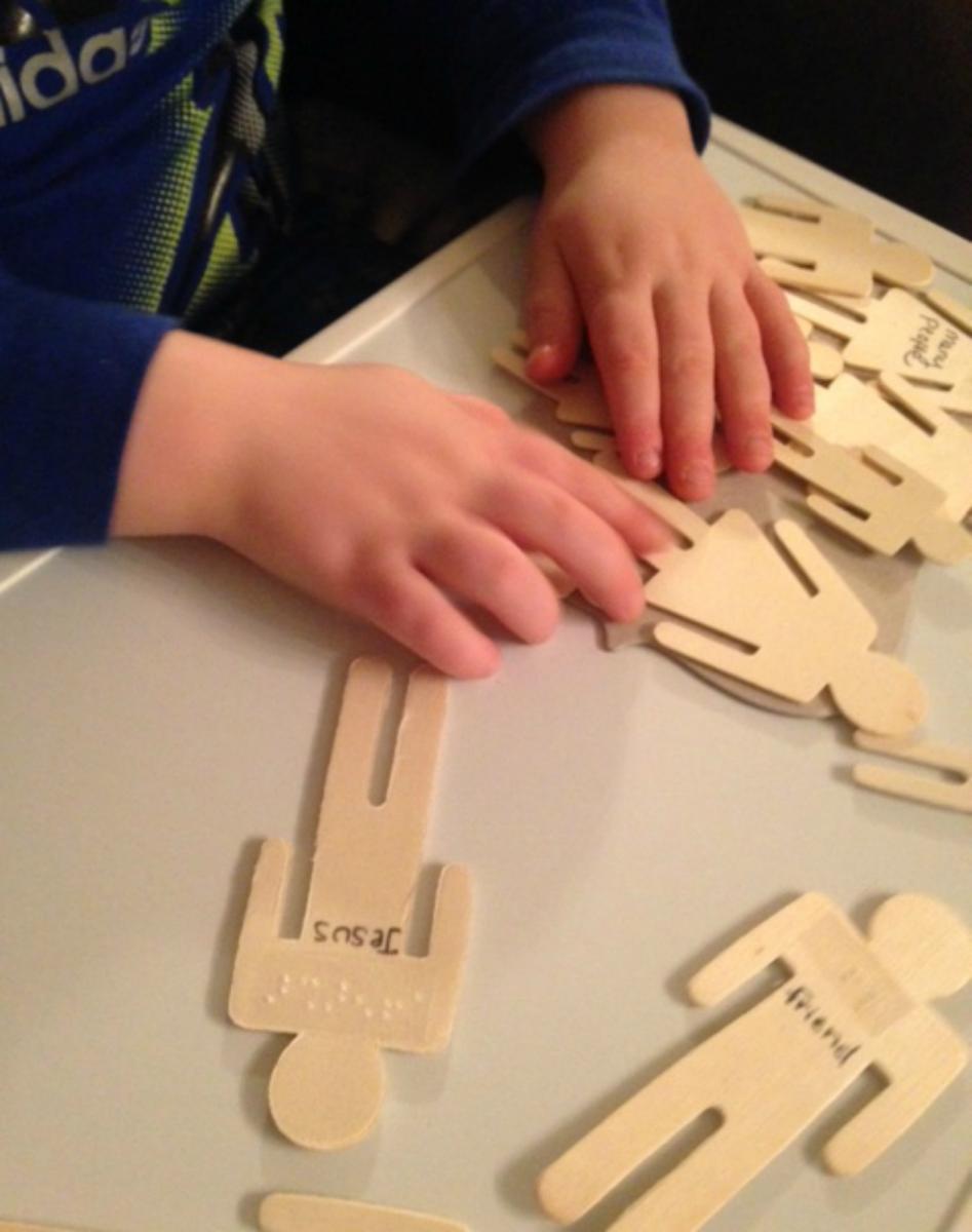 A boy explores wooden figures on a magnetic storyboard