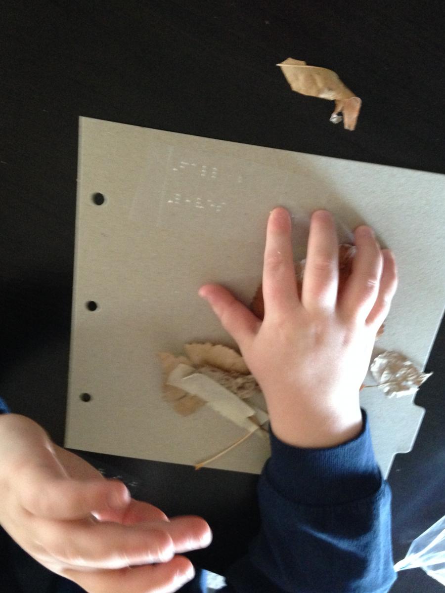 Reading braille page about fall leaves.