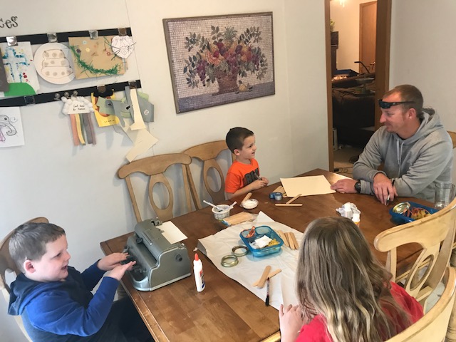 The family making their family sitting at the table making turkey jars