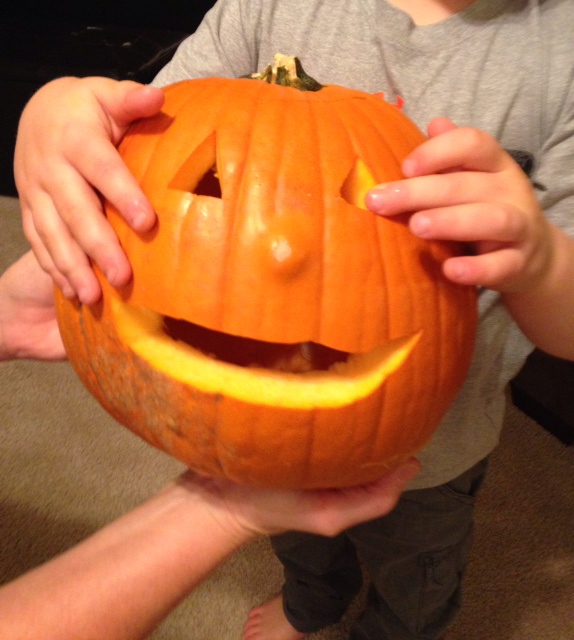 boy holding carved jack-o-lantern