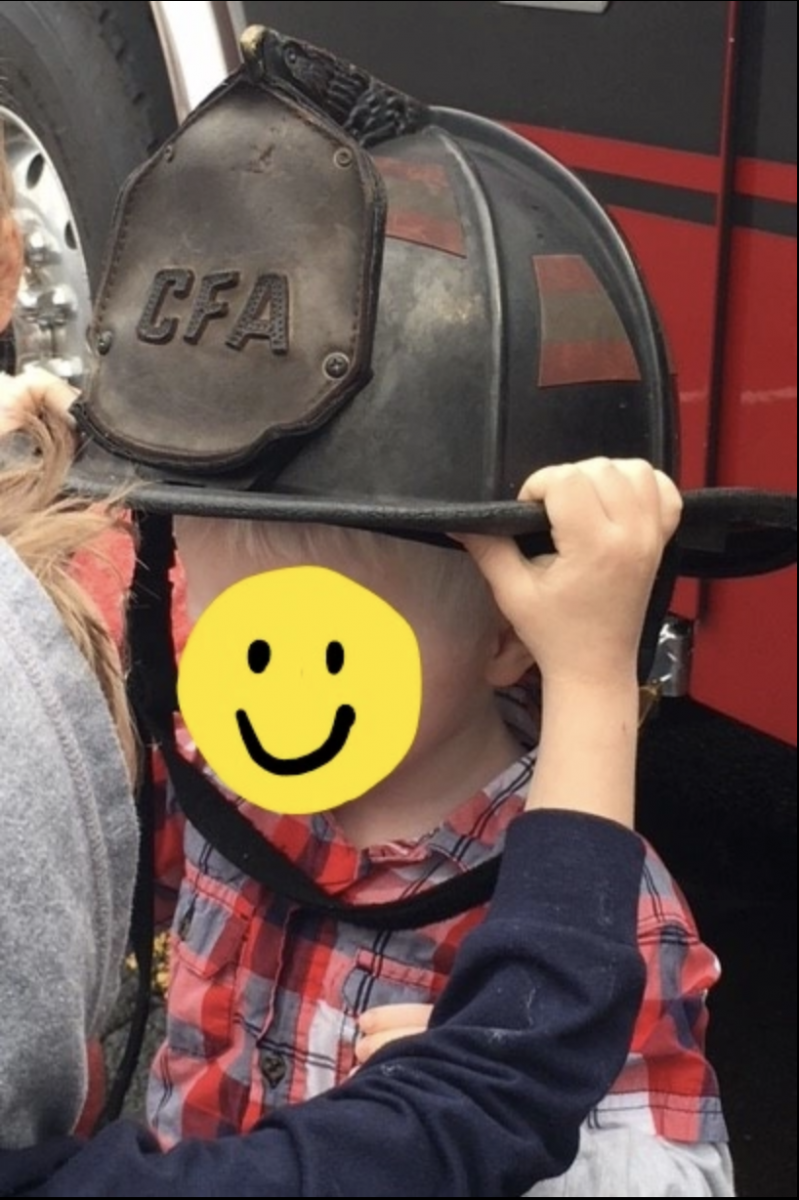 A young boy wearing a fireman's hat