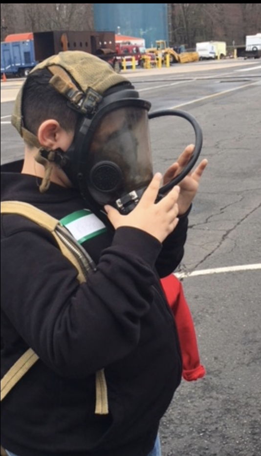 A boy tries on a fireman's mask