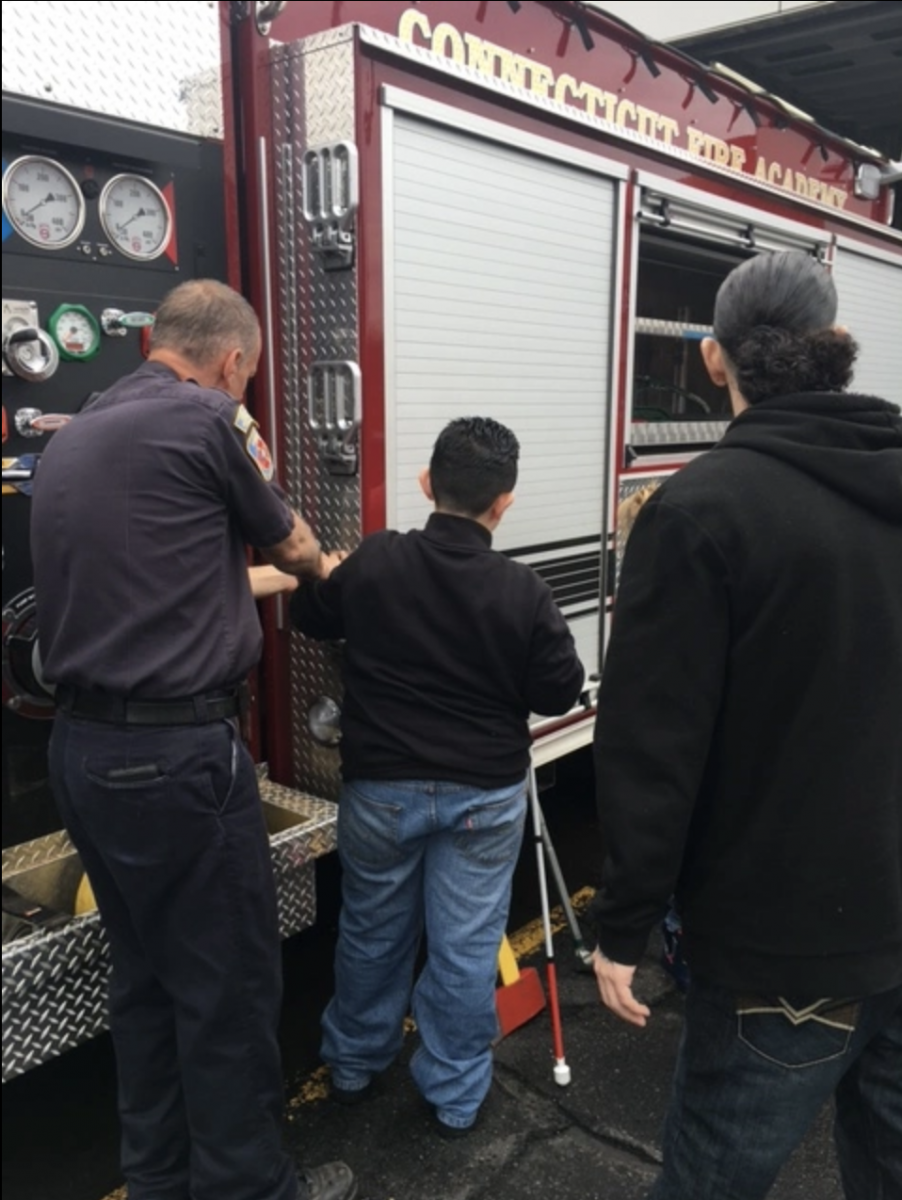 An older boy examines a fire truck.