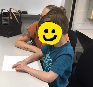 A boy reads braille checklist of fire safety tips