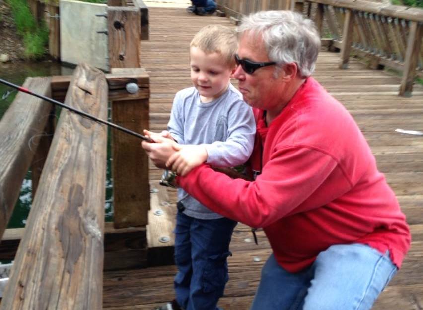 A young boy fishing with his teacher