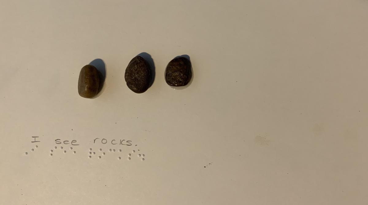 3 small stones with braille text 