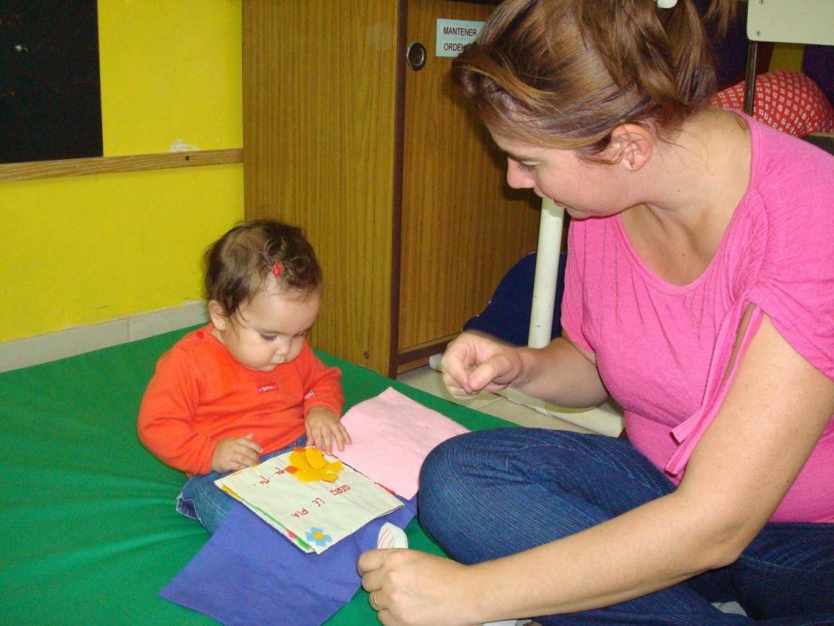 A young girl looks at a duck in a book