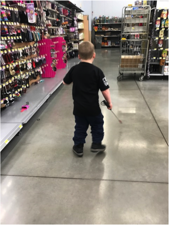 Boy using cane in aisle of grocery store