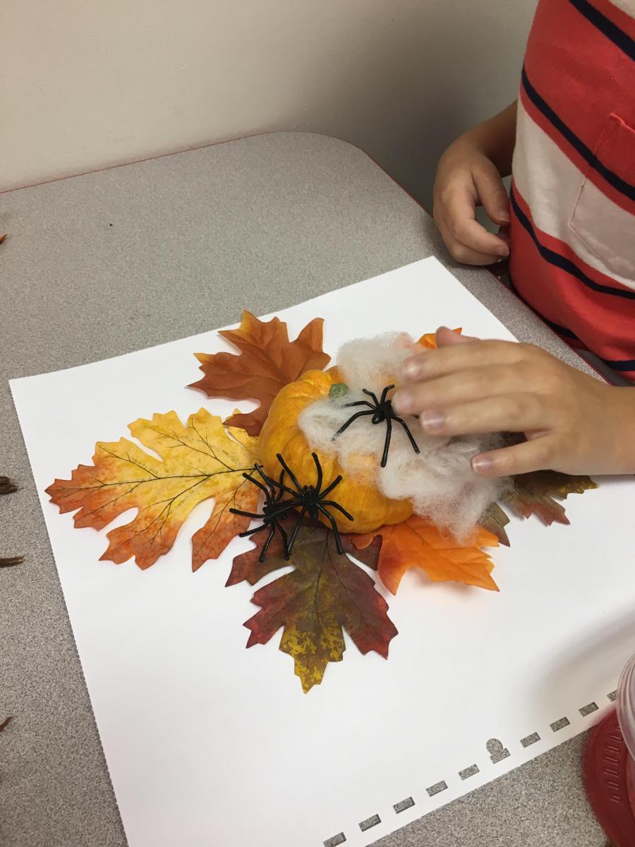 Putting spider and spiderweb on pumpkin