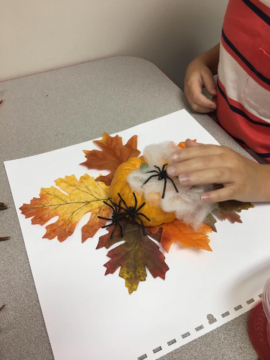 Putting spider and spiderweb on pumpkin Putting spider and spiderweb on pumpkin