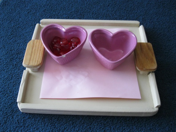 Set the tray up so that your child works left to right (pre-literacy). This is a simple transfer activity, the child takes the hearts from the bowl on the left and transfers them to the bowl on the right. two heart-shaped bowls