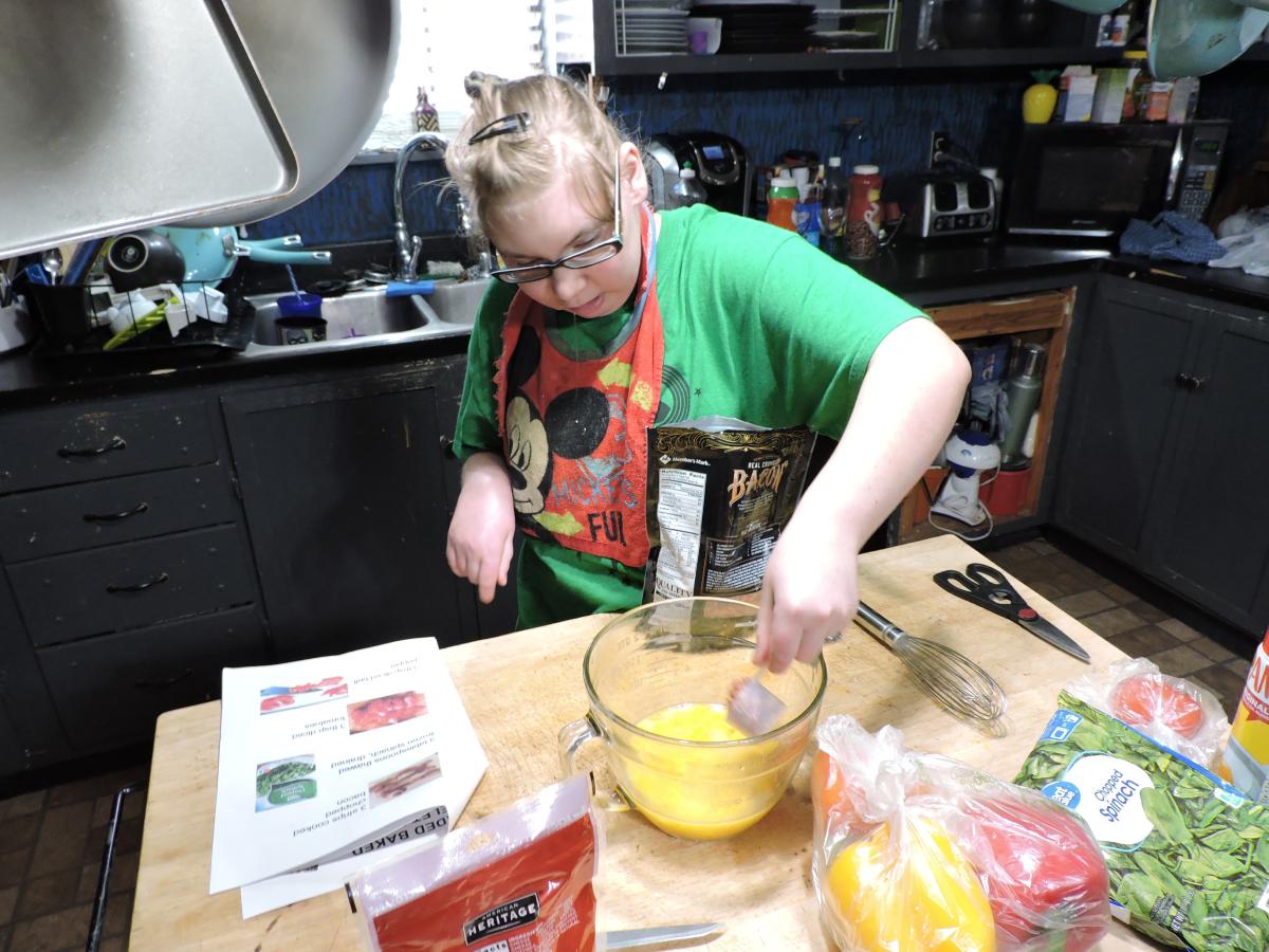 A girl stirs ingredients in a bowl