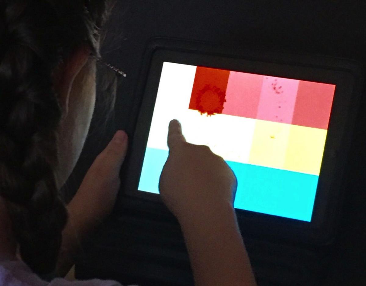 Child using iPad in darkened room