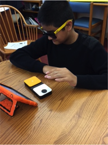 Boy using a switch to activate the iPad