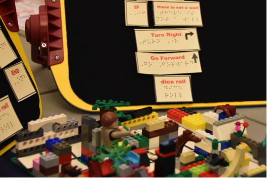 A student created Lego maze is shown with coding instructions in tactile print and Braille.