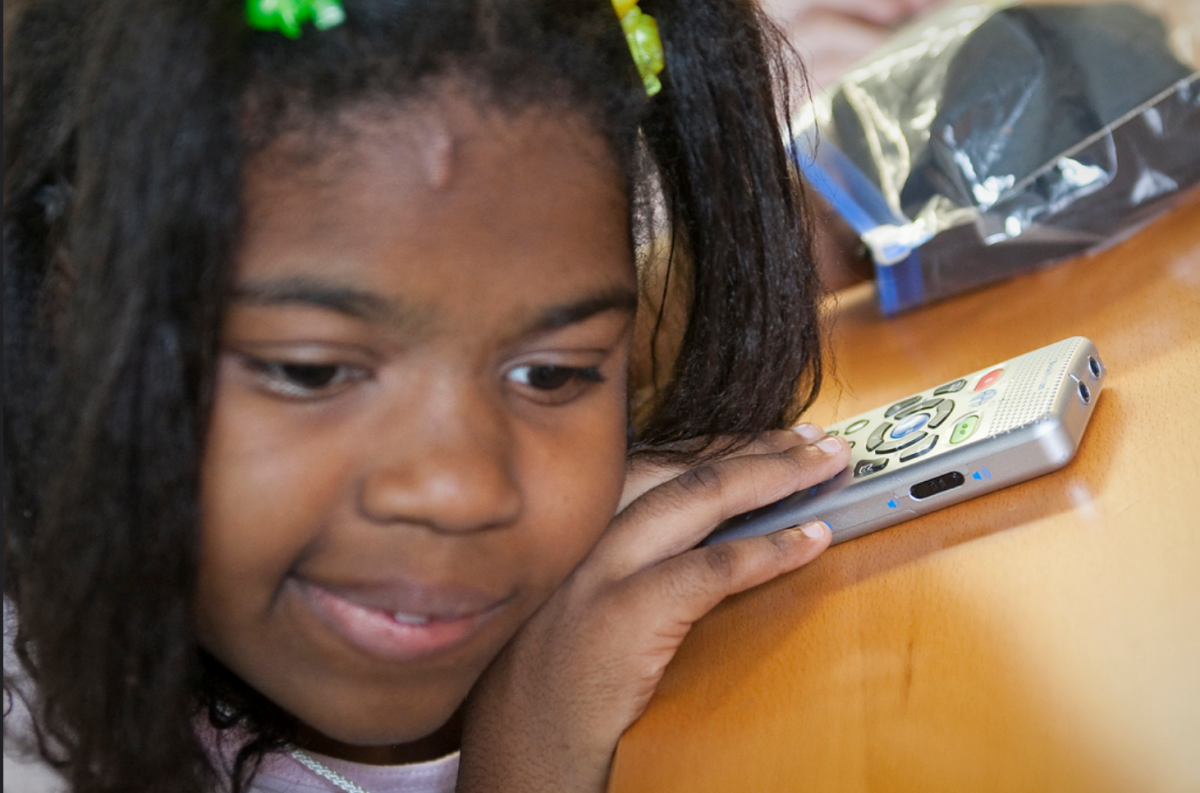 A young girl uses a Book Port Plus from APH