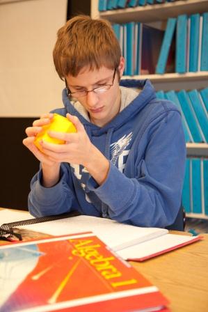 A student holds a 3-dimensional geometric shape